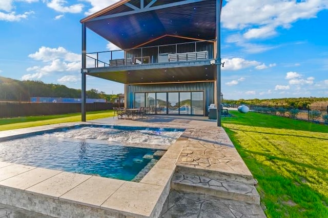 back of property featuring a yard, a fenced in pool, a patio area, and a balcony