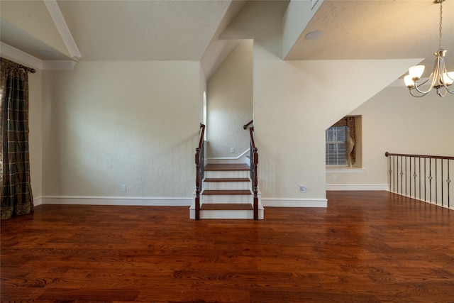 interior space featuring hardwood / wood-style floors, crown molding, and an inviting chandelier