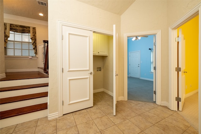 corridor with light tile patterned floors and crown molding