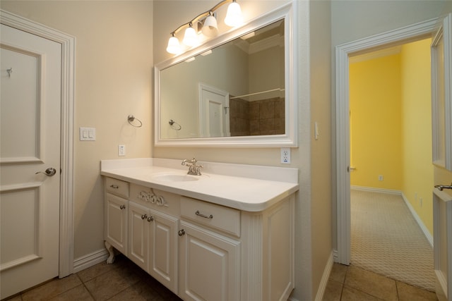 bathroom featuring tile patterned flooring, vanity, and crown molding