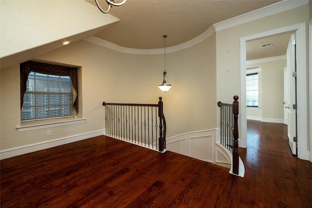 hall with a textured ceiling, dark hardwood / wood-style floors, and crown molding