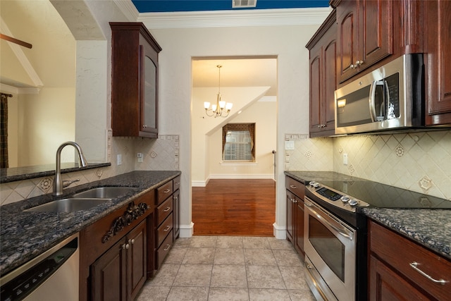 kitchen featuring stainless steel appliances, dark stone counters, sink, and ornamental molding