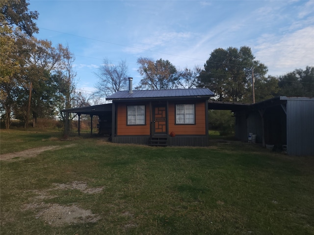 view of front of home with a carport and a front lawn