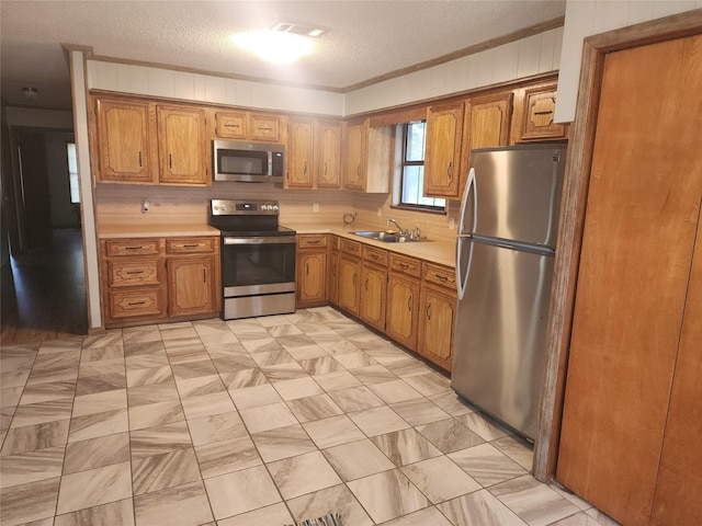 kitchen with a sink, visible vents, light countertops, appliances with stainless steel finishes, and brown cabinetry