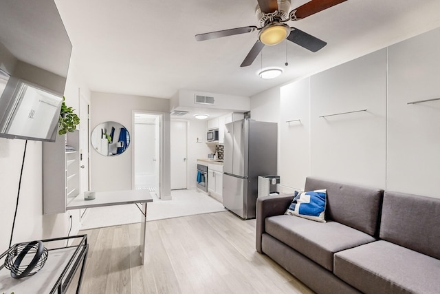 living room with ceiling fan and light hardwood / wood-style flooring