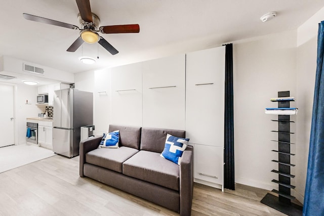 living room featuring ceiling fan and light hardwood / wood-style flooring