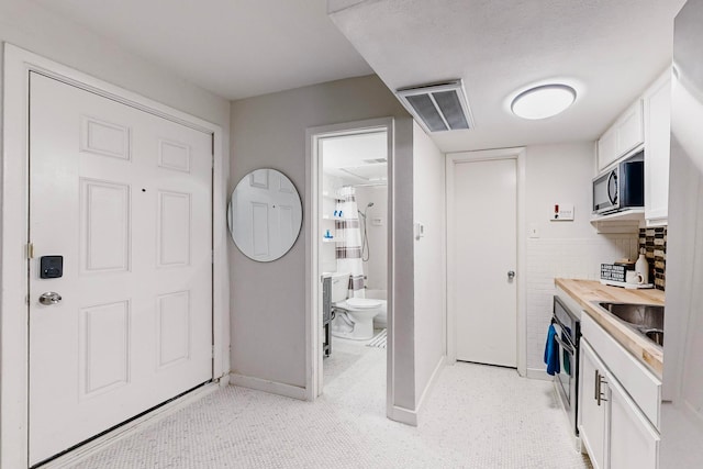 interior space featuring decorative backsplash and toilet