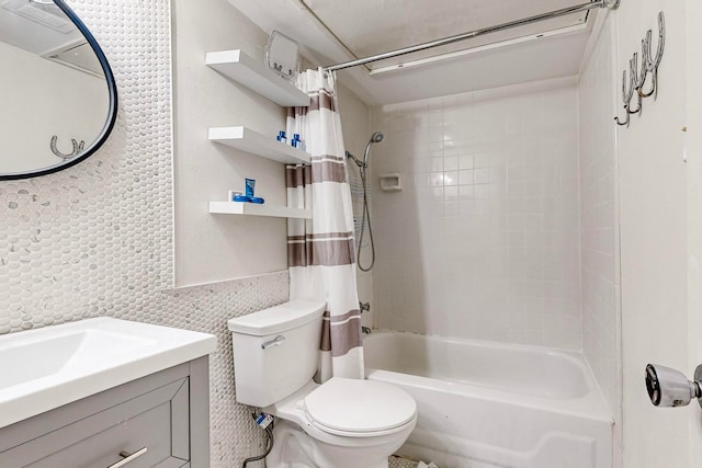 full bathroom featuring shower / bath combo with shower curtain, vanity, tile walls, and toilet