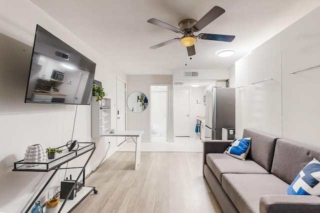 living room with ceiling fan and light hardwood / wood-style flooring