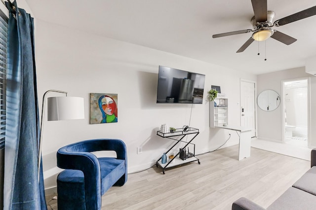 living room featuring light hardwood / wood-style flooring and ceiling fan