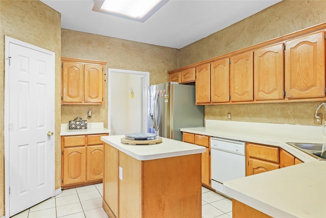 kitchen featuring dishwasher, sink, stainless steel fridge, a center island, and light tile patterned floors