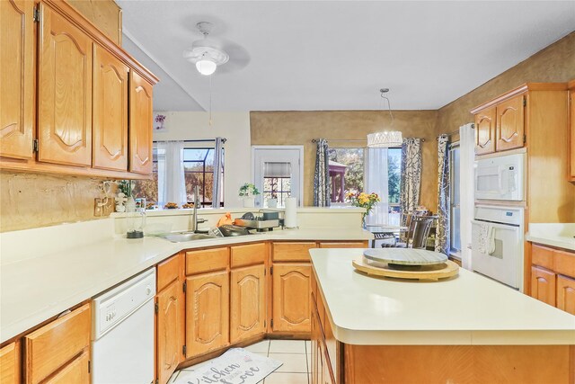 kitchen featuring light tile patterned flooring, a healthy amount of sunlight, white appliances, and sink