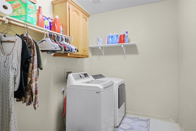 laundry room featuring washing machine and clothes dryer and cabinets