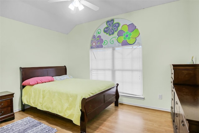 bedroom featuring light hardwood / wood-style floors, lofted ceiling, and ceiling fan