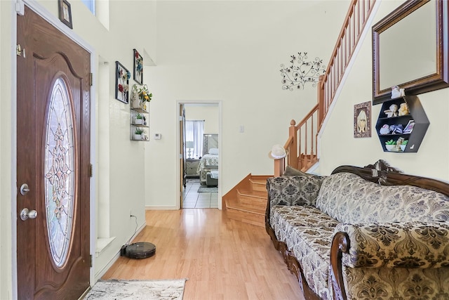 foyer featuring a towering ceiling and light hardwood / wood-style flooring