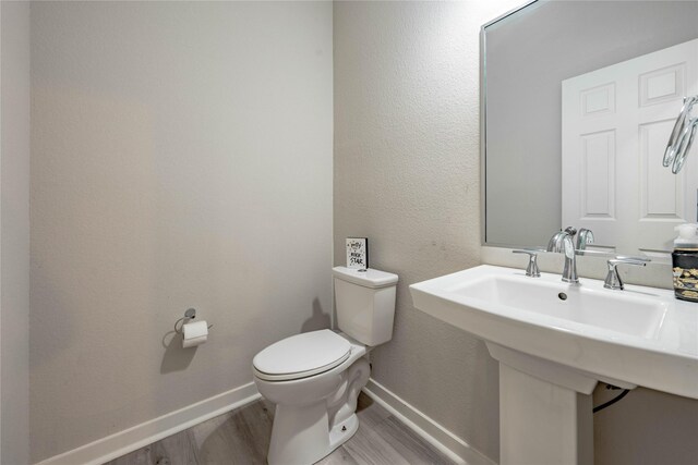 bathroom with wood-type flooring and toilet