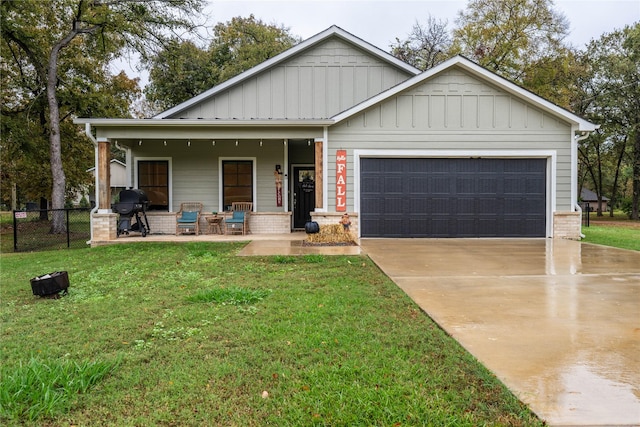 view of front of property with a garage, covered porch, and a front lawn