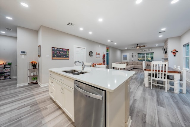 kitchen featuring light hardwood / wood-style floors, dishwasher, sink, and a center island with sink