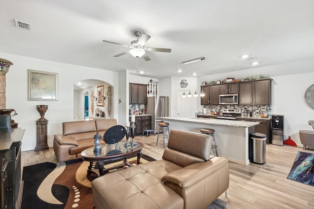 living room featuring light hardwood / wood-style floors and ceiling fan