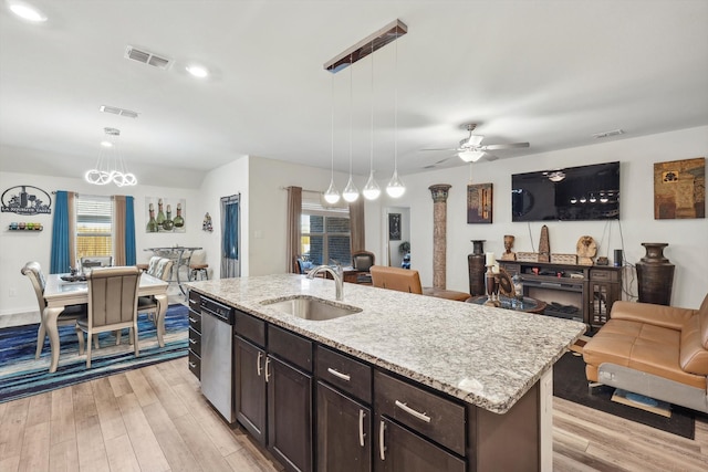 kitchen with pendant lighting, a center island with sink, light hardwood / wood-style floors, and sink