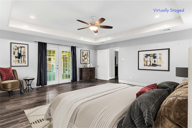 bedroom with french doors, a raised ceiling, dark hardwood / wood-style flooring, and access to outside