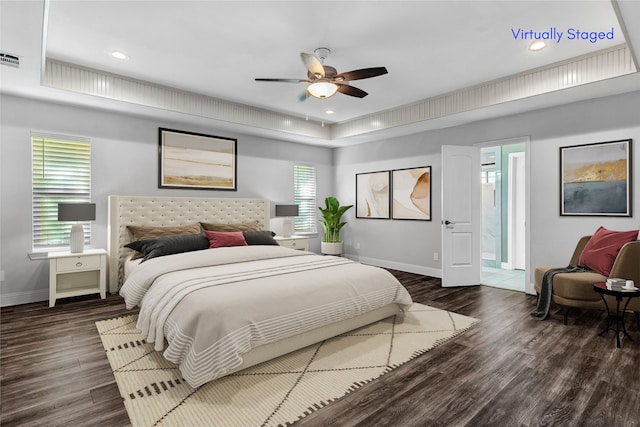 bedroom with ceiling fan, connected bathroom, and dark hardwood / wood-style flooring