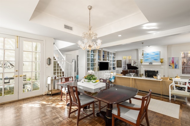 dining space featuring french doors, parquet flooring, a tray ceiling, and a notable chandelier