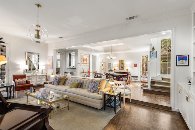 living room with an inviting chandelier, a tray ceiling, ornamental molding, and dark parquet floors