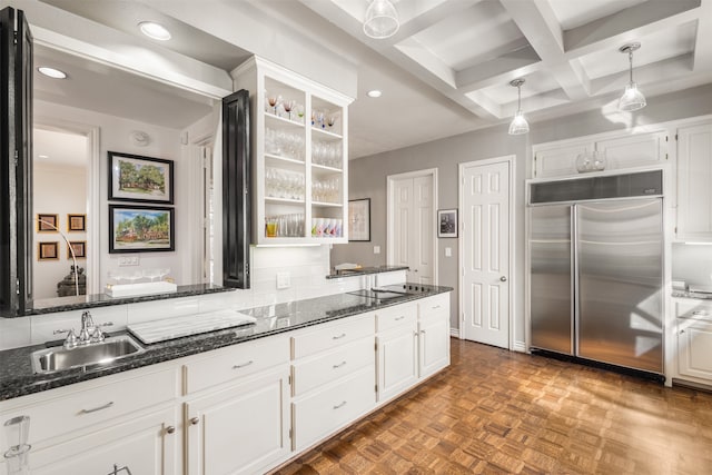 kitchen featuring built in fridge, beamed ceiling, white cabinetry, sink, and coffered ceiling