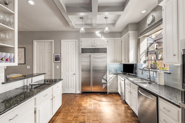 kitchen with white cabinetry, appliances with stainless steel finishes, sink, and dark stone counters