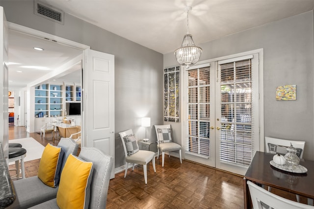 living area with dark parquet floors, french doors, and a chandelier