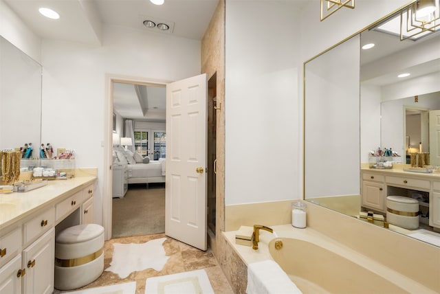 bathroom featuring vanity and tiled bath