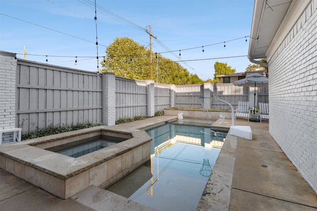 view of swimming pool featuring an in ground hot tub and a patio area