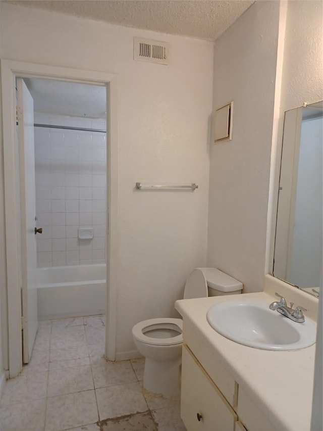 full bathroom with vanity, toilet, a textured ceiling, and tiled shower / bath