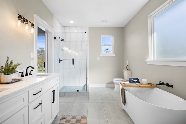 full bathroom featuring toilet, vanity, tile patterned floors, and separate shower and tub