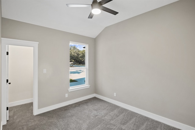 carpeted spare room featuring ceiling fan and lofted ceiling