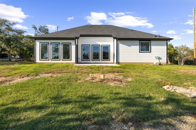 rear view of property featuring a yard