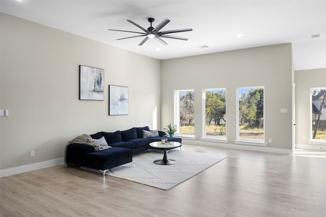 living room with ceiling fan and light hardwood / wood-style flooring