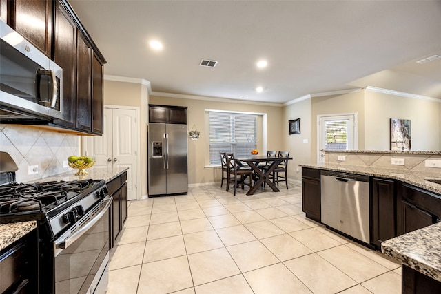 kitchen with stainless steel appliances, ornamental molding, light stone counters, and dark brown cabinetry