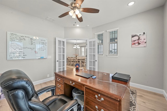 office area with french doors, light hardwood / wood-style flooring, and ceiling fan with notable chandelier