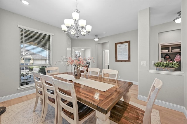 dining space with an inviting chandelier and light hardwood / wood-style floors