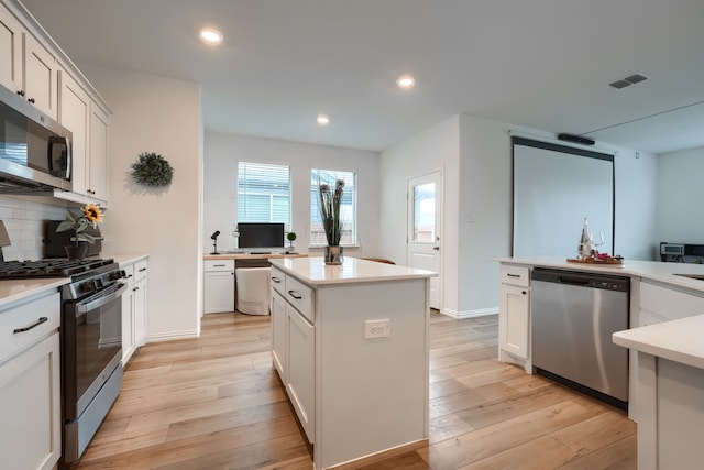 kitchen with a center island, white cabinetry, and stainless steel appliances