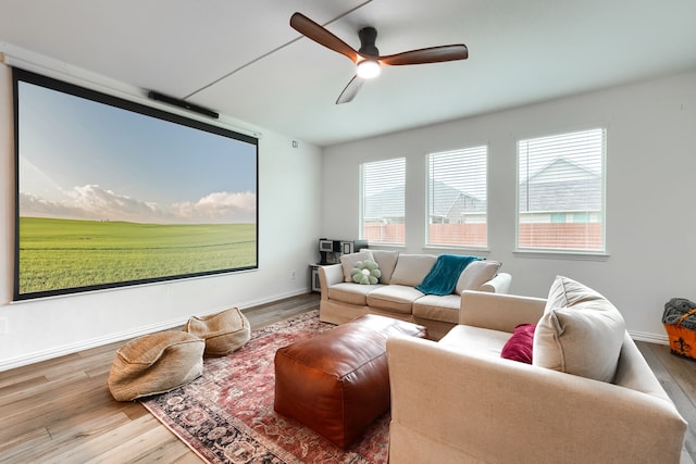 cinema room featuring ceiling fan and hardwood / wood-style flooring