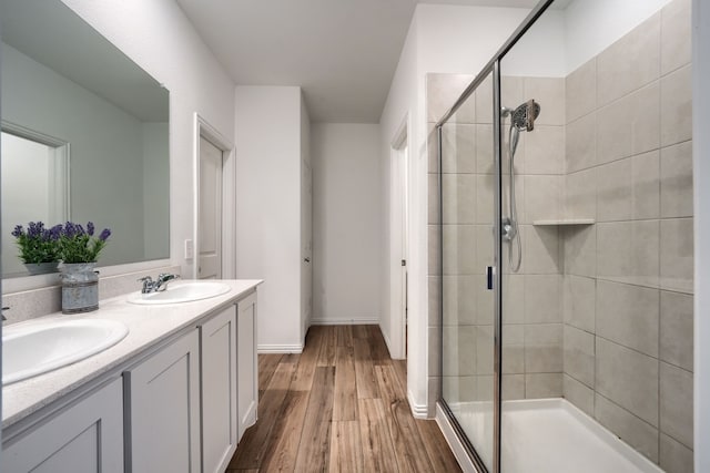 bathroom featuring wood-type flooring, vanity, and a shower with shower door