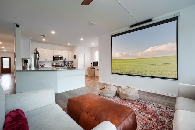 living room with ceiling fan and light wood-type flooring