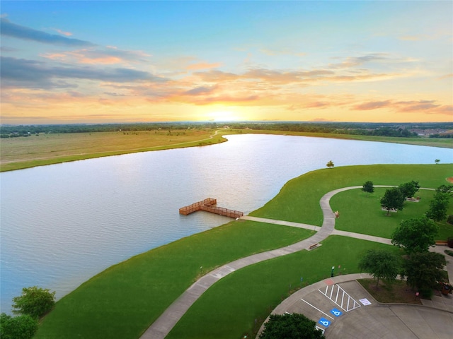 aerial view at dusk featuring a water view