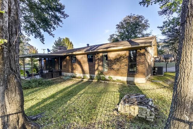 back of house with a lawn and central AC