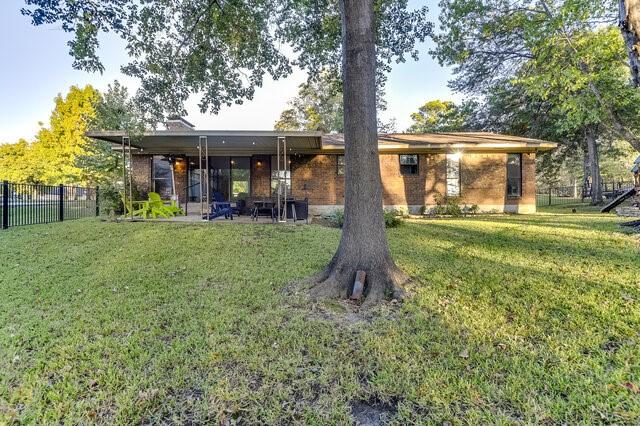 rear view of house with a patio area and a yard