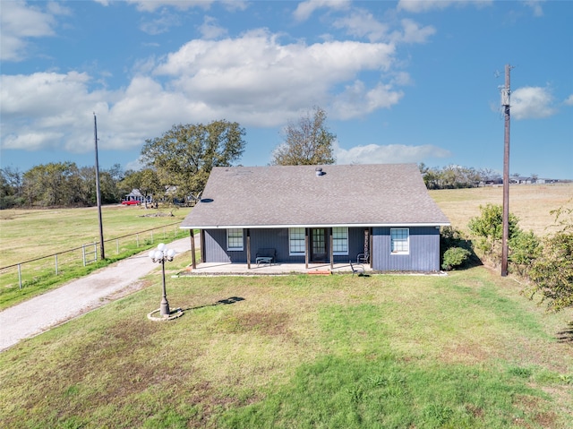 ranch-style home featuring a rural view and a front yard