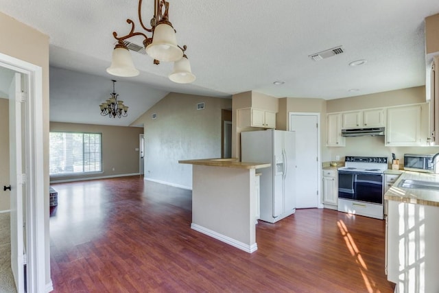 kitchen featuring a chandelier, dark hardwood / wood-style floors, pendant lighting, white appliances, and white cabinets